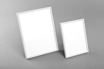 White frames for paintings or photographs on gray background.