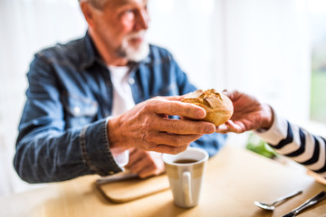 Senior couple eating breakfast at home.