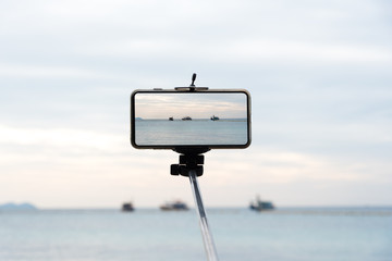 Mobile monopod with sea view screen phone Smartphone Monophonic visible in the arm. 