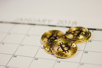 Golden bitcoin coins on calendar file