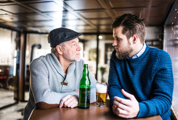 Senior father and his young son in a pub.