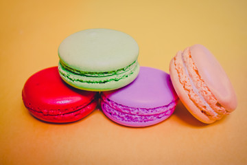 Cake macaron or macaroon isolated on yellow background, sweet and colorful dessert.Pastel