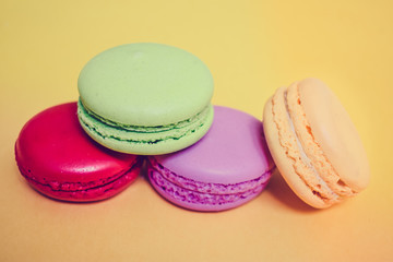 Cake macaron or macaroon isolated on yellow background, sweet and colorful dessert.Pastel