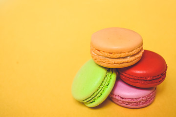 Cake macaron or macaroon isolated on yellow background, sweet and colorful dessert.Pastel