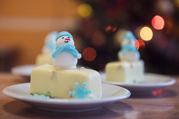 Christmas dessert with snowman on lights bokeh background