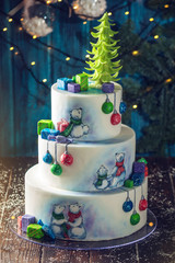 Christmas colorful three-Tiered cake decorated with drawings of Teddy bears, gift boxes and a green tree top
