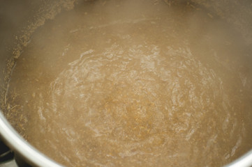 process of making home beer from malt. Craft beer from barley and dark malt. the boiling surface of the future beer