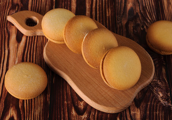 Delicious biscuits with banana filling on an old wooden table. Sweet dessert