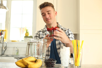 Young man making a healthy smoothie. 