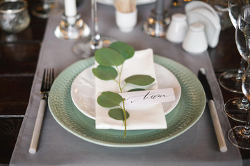personal seating chart on a dinner party plate. The name written in ink and a pen, calligraphy on...