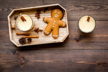 Eggnog for christmas evening. Two glasses near gignerbread cookie on dark wooden background top view copyspace