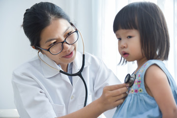 Female Doctor examining a little girl.