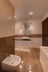 A bathroom from a marbled tile from a bidet and a bathroom