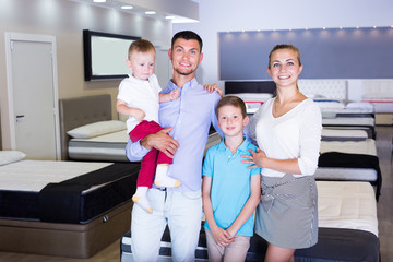 Happy family looking for new mattress in salon
