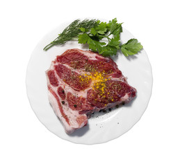 raw pork steak on white plate.
