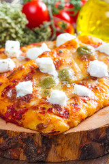 couple of pizza with olives and margherita on wood