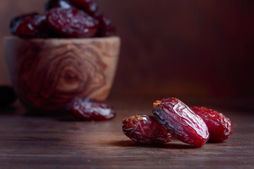 Juicy dates on wooden table .