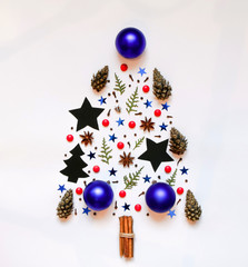 Christmas tree from small objects: stars, Christmas tree decorations, anise, cinnamon, cones, cones. On a white background. Top view. christmas, new year