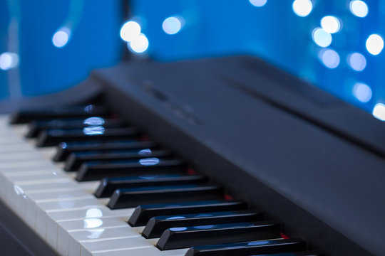 Piano keys side view on a blue bokeh background