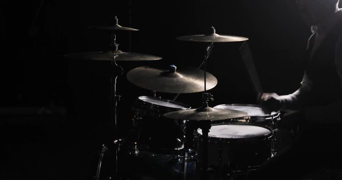 Drummer Plays Drums Kit. Drummer Hand Silhouette With Drumstick. Close up of Drummer Hand Playing Drum Plate on Rock Concert. Rock Band Performing on Stage