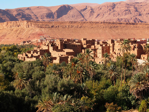 The moroccan town near Tinghir consisting of the clay made adobe kasbahs between gorgeous brown high Atlas mountains (stone desert in the canyon Gorge du Dades) and a huge oasis - Africa, Morocco