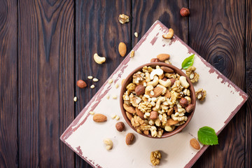 Mix of dried fruits and nuts on a wooden background. The concept of a healthy dessert. Top view with copy space.