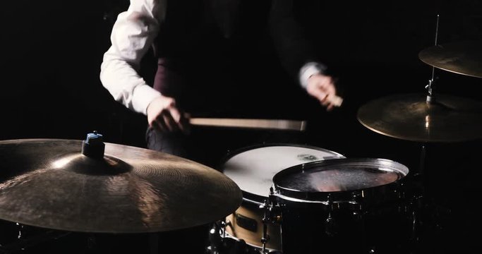 Drummer Plays Drums Kit. Drummer Hand Silhouette With Drumstick. Close up of Drummer Hand Playing Drum Plate on Rock Concert. Rock Band Performing on Stage