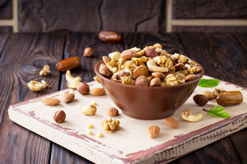 Mix of dried fruits and nuts on a wooden background. The concept of a healthy dessert. Copy space.