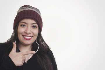 beautiful muslim woman wearing hat and listening to the music and pointing her finger