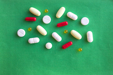 colorful pills and drugs in close up.assorted pills and capsules in medicine. drugs of various kinds and different colors. Medicine on green background