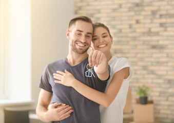 Young happy couple with key at new home