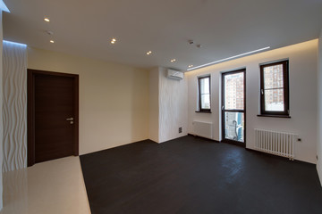 A drawing room with a black wooden floor and big windows in a floor