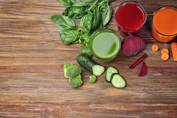 Glasses with various fresh juices and ingredients on table