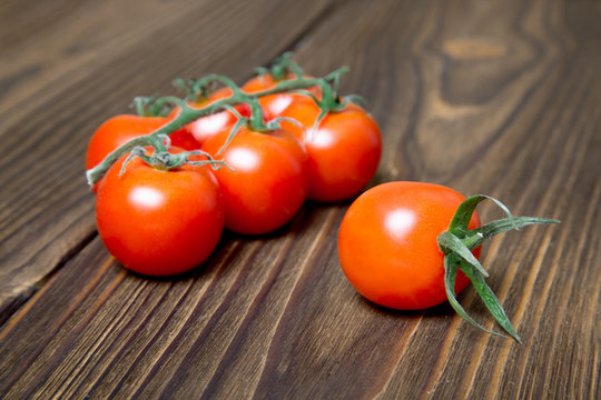 Ripe tomatoes on dark wooden background