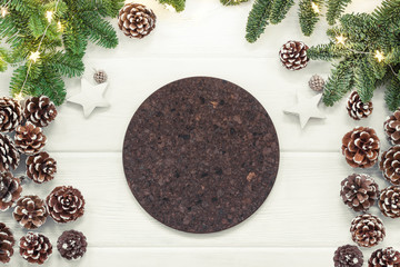 Christmas background with fir tree and empty round cork coaster on white wooden board