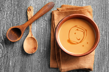 Bowl with sweet caramel sauce on table