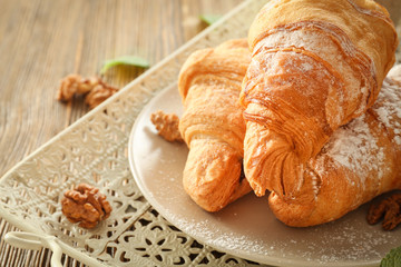 Vintage tray with tasty croissants on wooden table, closeup