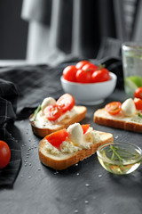 Delicious sandwiches with cherry tomatoes and mozzarella on table
