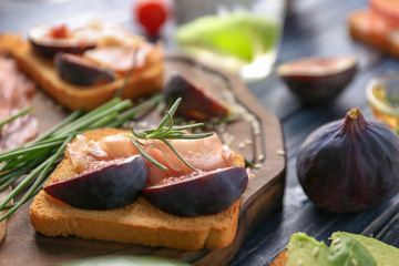Delicious sandwich with fig and lunch meat on table, closeup