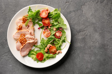 Plate with meat and delicious vegetable salad on grey background, top view