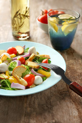 Plate with delicious fresh salad on table