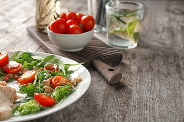 Plate with delicious fresh salad on table