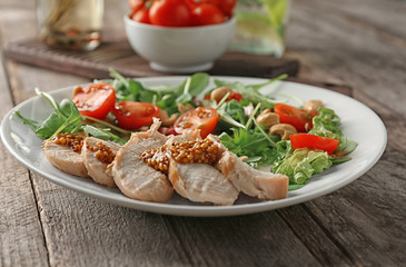 Plate with meat and delicious fresh salad on table