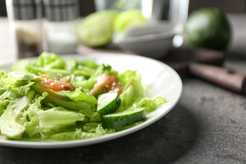 Plate with delicious fresh salad on table, closeup