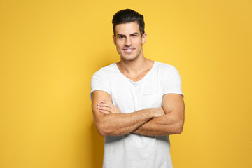 Handsome young man in casual clothes on color background
