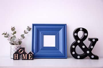 Mockup of blank frame with decor on light background