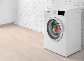 Laundry in washing machine on brick wall background