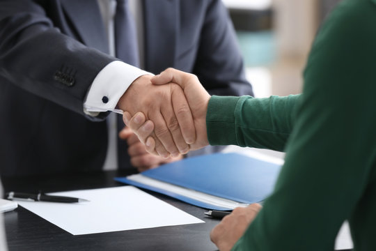 Notary and client shaking hands in office