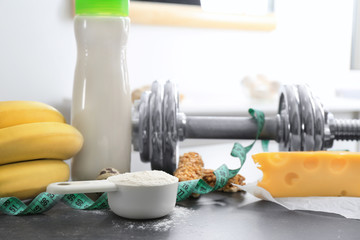 Scoop with protein powder, shake in bottle and products on table