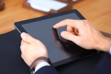 Young male notary using tablet in office, closeup